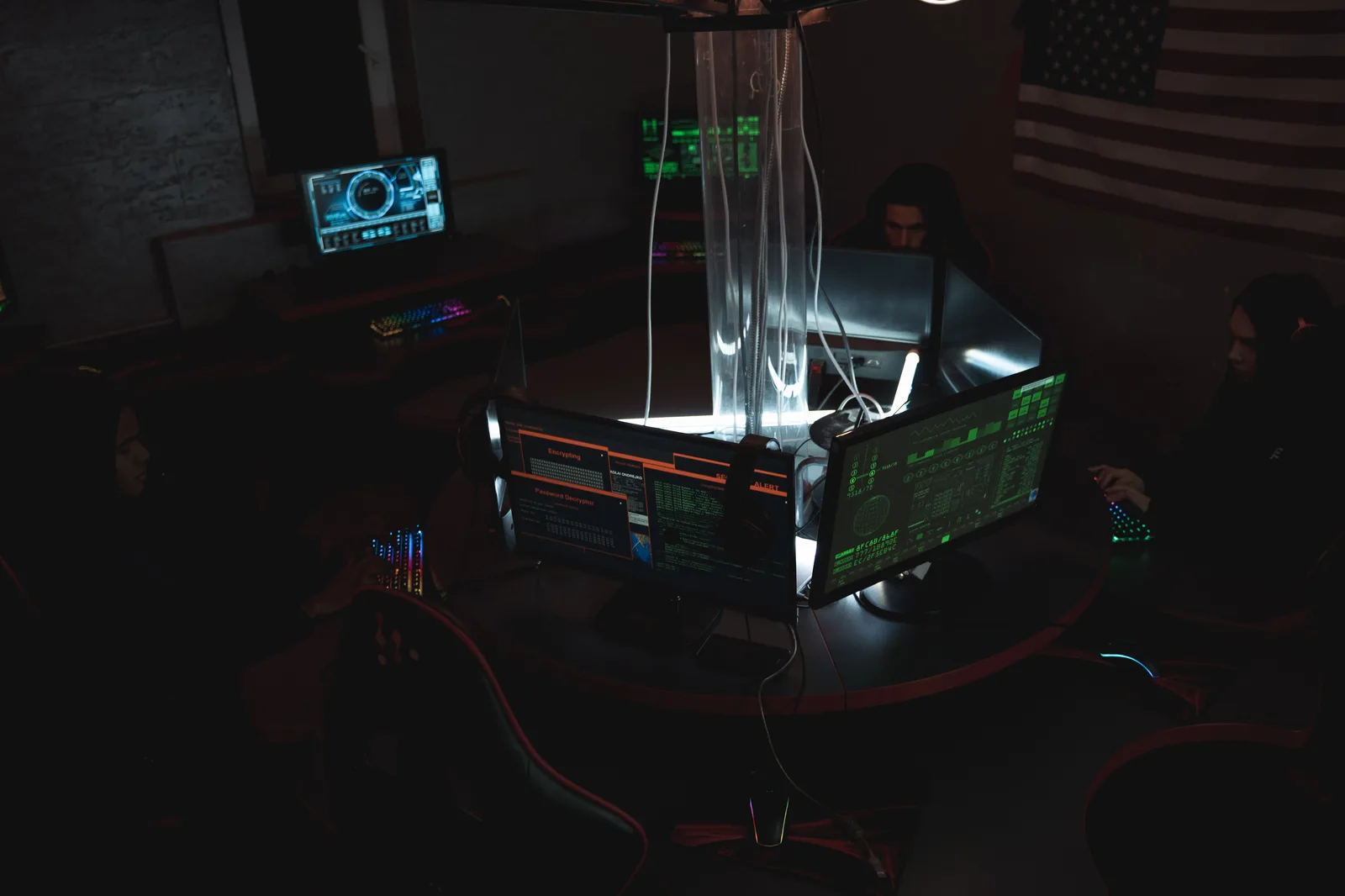 Engineer reviewing code and system dashboards on large monitors in a dark modern operations center