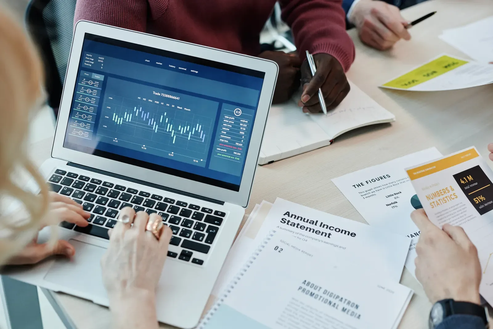 Business professionals analysing charts and reports on a laptop during a meeting