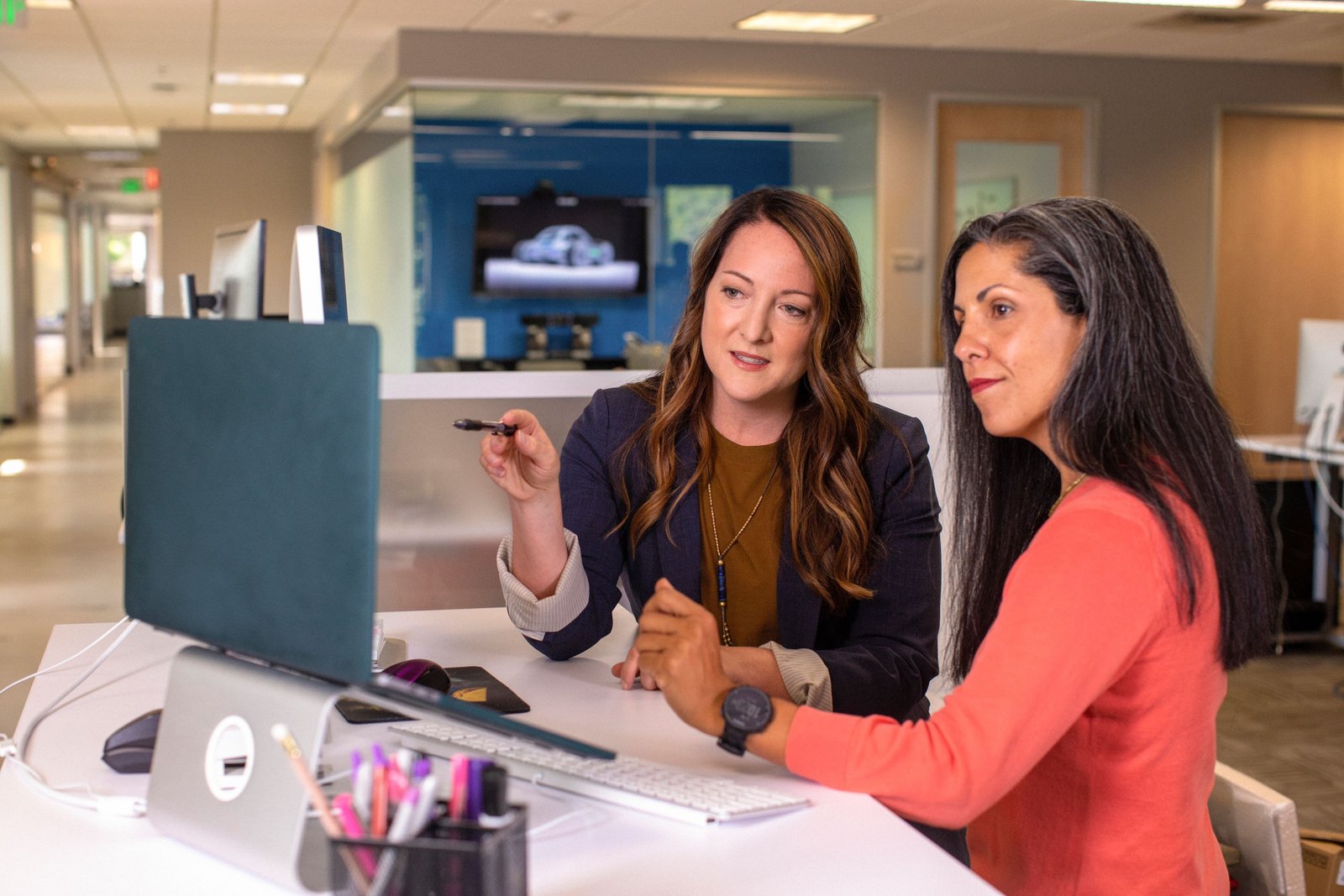 Marketing team collaborating around a laptop