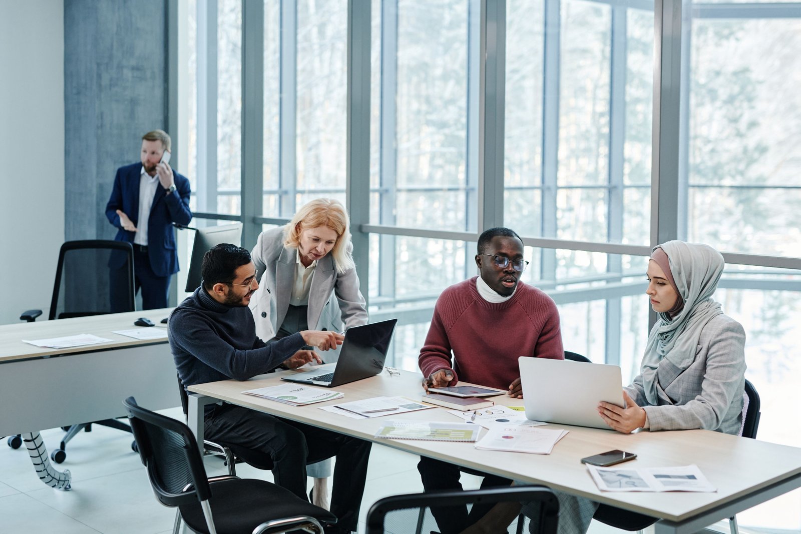 Diverse engineering team collaborating around a table in a bright office